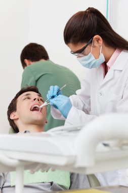 Dentist working on patient's teeth clipart