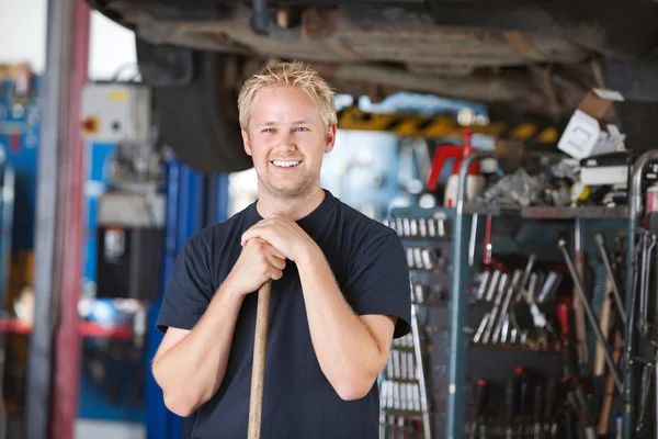 Mechanik uśmiechający się gospodarstwa miotła — Zdjęcie stockowe
