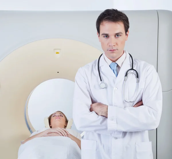 Doctor standing in front of CT scan machine — Stock Photo, Image