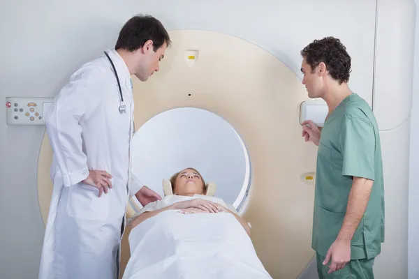 Arzt mit Techniker untersucht Patient — Stockfoto