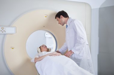 Young woman receiving CT scan clipart