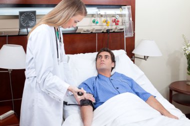 Doctor checking blood pressure of patient clipart