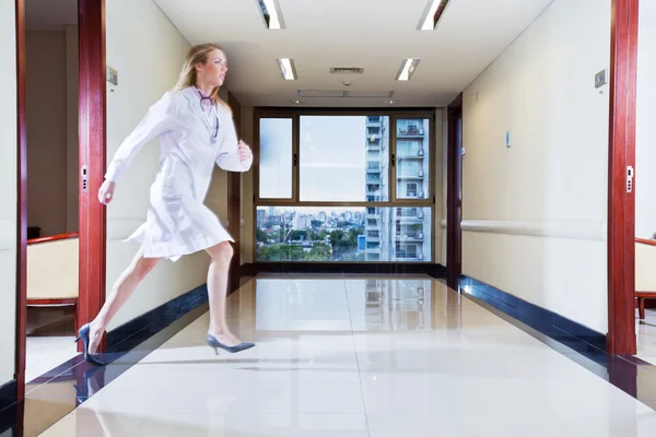 Kobieta lekarz pędzi w korytarzu — Zdjęcie stockowe