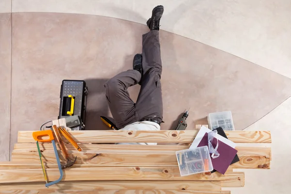 Чоловік працює під дерев'яною дошкою — стокове фото