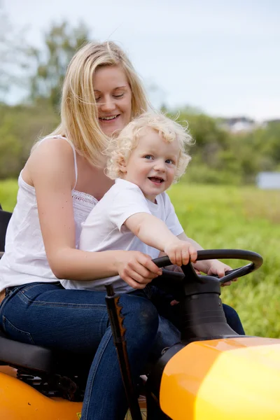 母亲与儿子驾驶拖拉机 — 图库照片