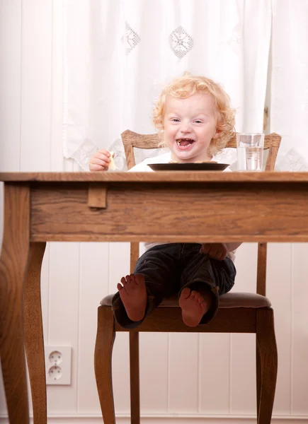Criança excitada na mesa de refeições — Fotografia de Stock