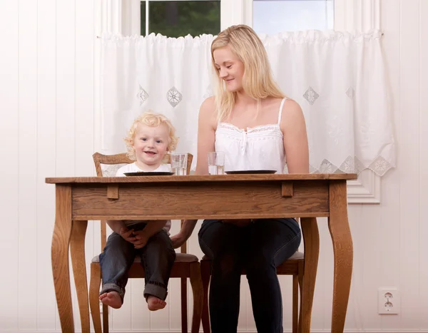 Mor och barn vid bordet — Stockfoto