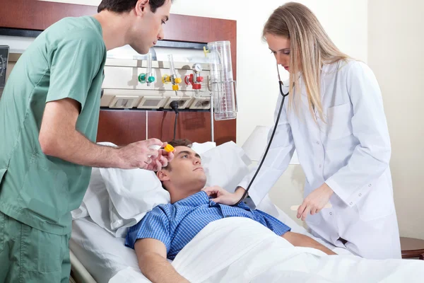 Doctor checking young patient — Stock Photo, Image