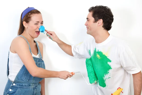 Couple playing with paint against wall — Stock Photo, Image