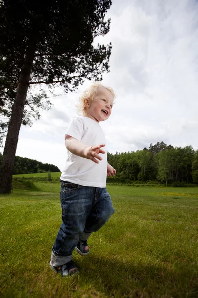 Взволнованный веселый мальчик бежит — стоковое фото