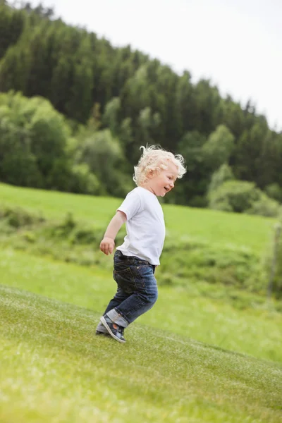 Мальчик-косолапый гуляет один в саду — стоковое фото