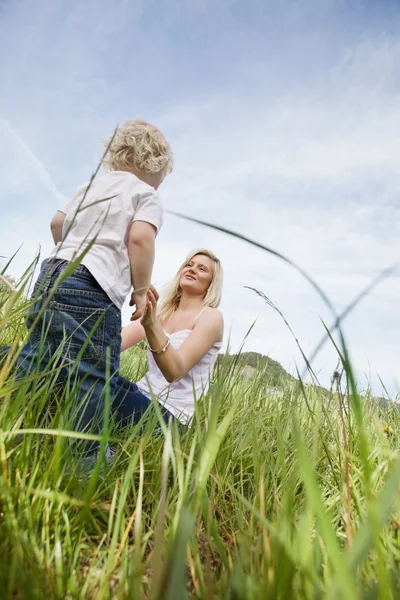 母と草の中で少年 — ストック写真