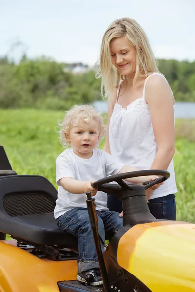 Хлопчик малюк сидить на газон трактор — стокове фото