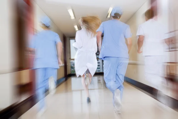Врач и медсестра бегут в проходе — стоковое фото