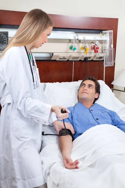 Médico revisando la presión arterial del paciente — Foto de Stock