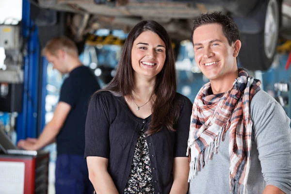 Retrato de una joven pareja sonriente en un taller mecánico —  Fotos de Stock