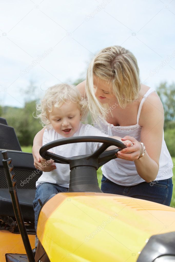 Young Boy with Mother on Garden Tractor