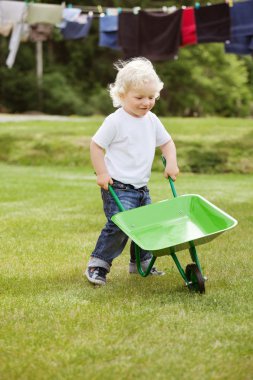 Boy pushing a wheelbarrow clipart