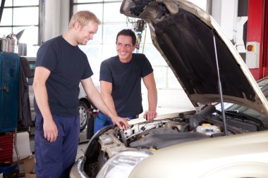 Two Mechanics Working on a Car clipart