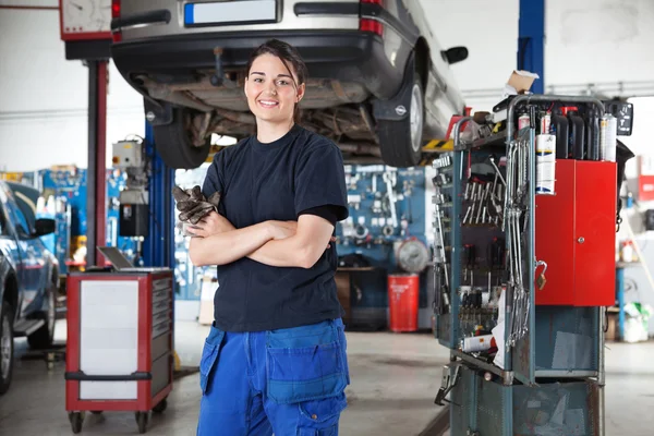 Улыбающаяся молодая женщина механик в гараже — стоковое фото