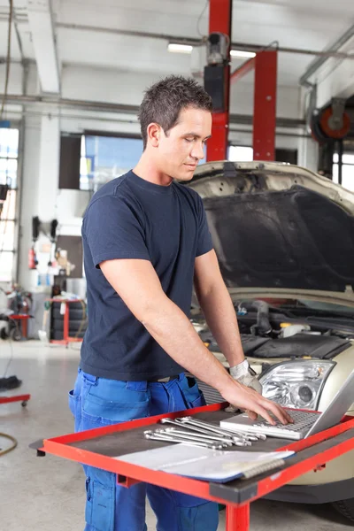 Mechanic using laptop in garage — Stock Photo, Image