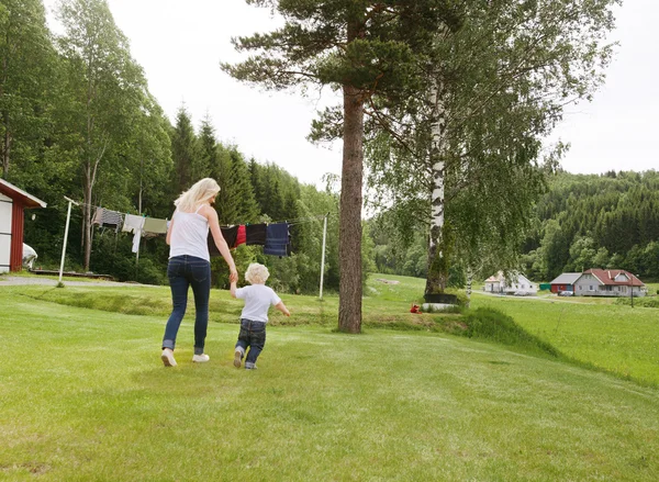 Frau und Kind spazieren im Garten — Stockfoto