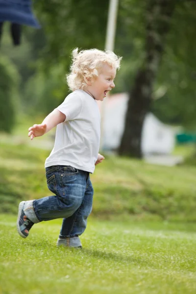 Мальчик бегает в саду — стоковое фото