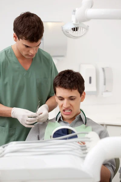 Dentysta pacjenta patrząc na zęby — Zdjęcie stockowe