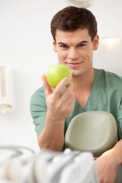 Apple ile gülümseyen erkek diş hekimi — Stok fotoğraf