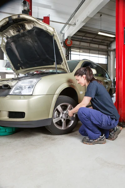 Female mechanic changing wheel Stock Photo