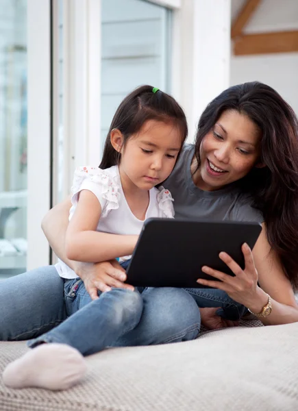 Счастливые мать и дочь с цифровыми технологиями — стоковое фото