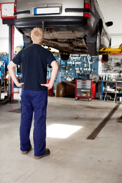 Mechanik patrząc na samochód — Zdjęcie stockowe
