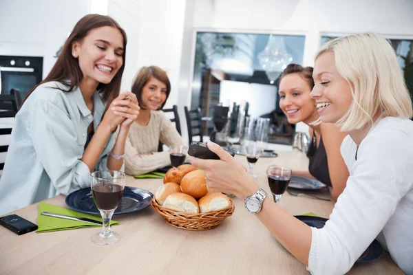 Amigos sonrientes en la mesa de comedor —  Fotos de Stock