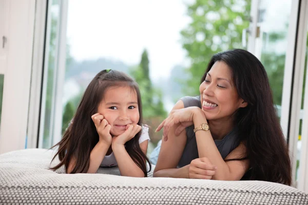 Mother and daughter on couch laughing — Stock Photo, Image