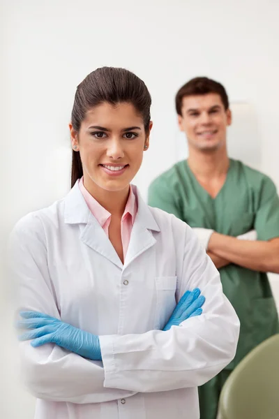Glad kvinnliga tandläkare leende med armarna korsade — Stockfoto