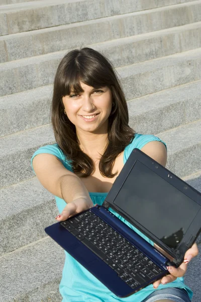 Jovem mulher na rua com um laptop . — Fotografia de Stock