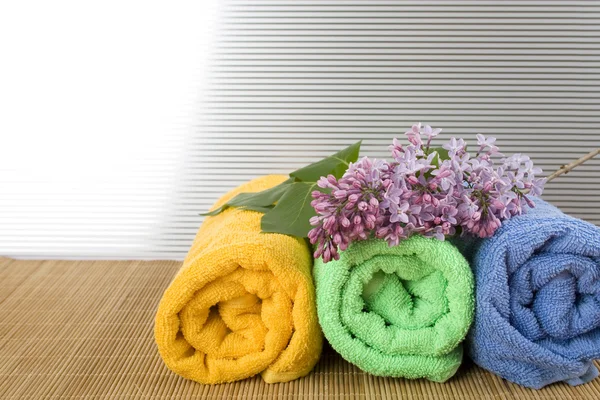 Towels folded lie next to them a branch of lilac — Stock Photo, Image