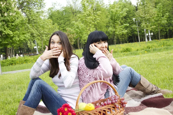 Mother and daughter talk on the phone in the park — Stock Photo, Image