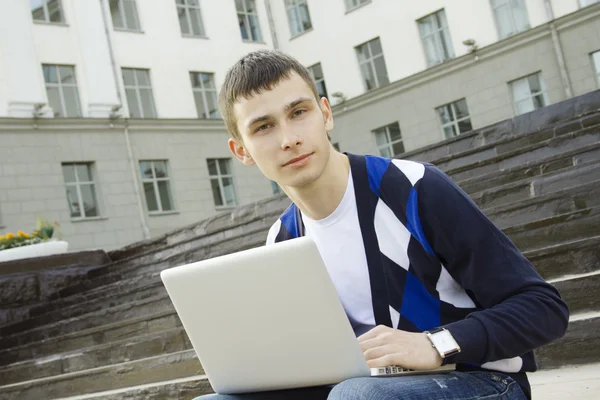 Joven estudiante trabajando en un portátil — Foto de Stock