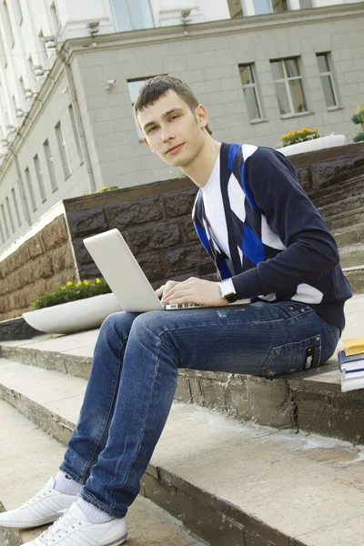 Bir dizüstü bilgisayarda çalışan genç bir öğrenci — Stok fotoğraf