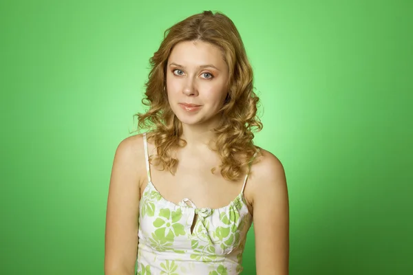 Schöne junge Frau auf grünem Hintergrund — Stockfoto