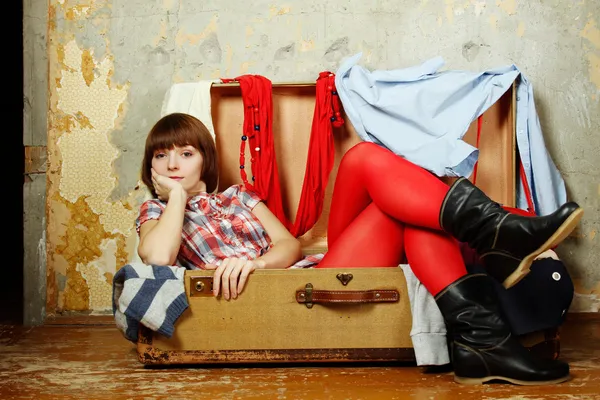 Mulher atraente sentada em uma mala — Fotografia de Stock