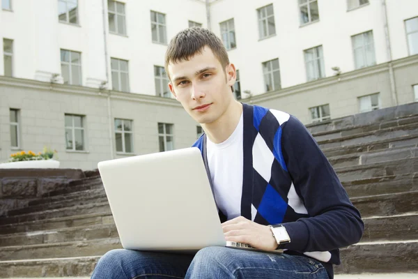 Молодой студент работает на ноутбуке Лицензионные Стоковые Фото
