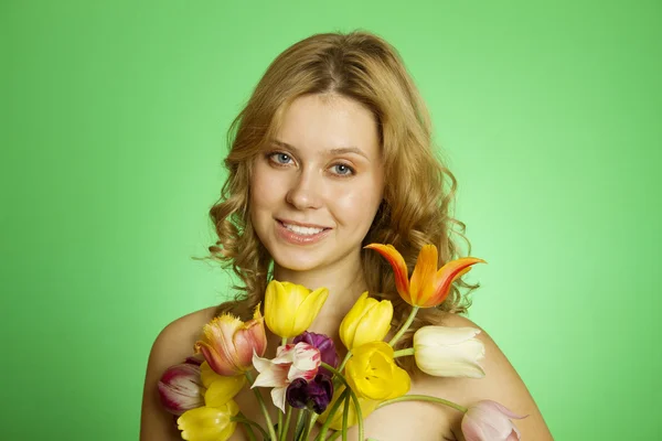 Glückliche junge Frau umarmt einen Strauß Tulpen — Stockfoto