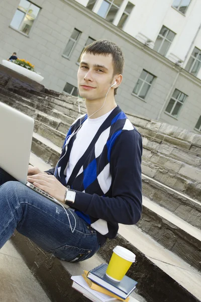 Joven estudiante trabajando en un portátil . — Foto de Stock