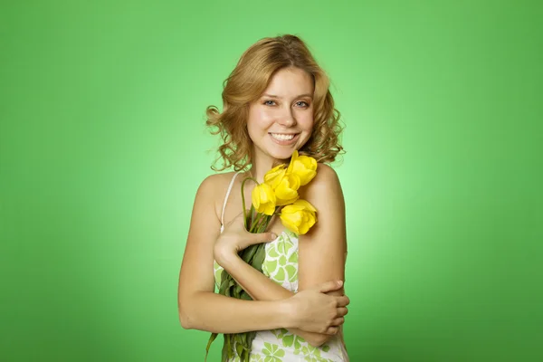 stock image Attractive girl hugging a bouquet of yellow tulips