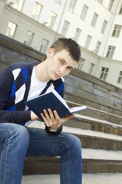 Estudiante masculino en el campus con libros de texto — Foto de Stock