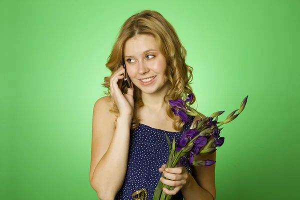 Mulher ao telefone e segura um buquê de flores — Fotografia de Stock