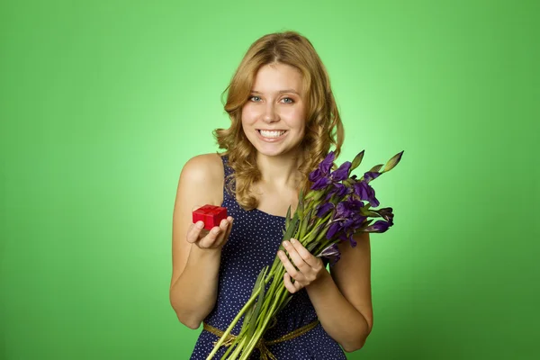 Ragazza attraente che tiene fiori e una scatola regalo — Foto Stock