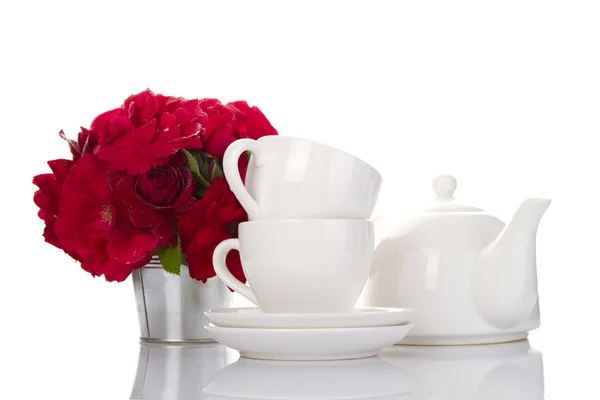 Λευκά σερβίτσια για το τσάι και ένα μπουκέτο από τριαντάφυλλα — Φωτογραφία Αρχείου